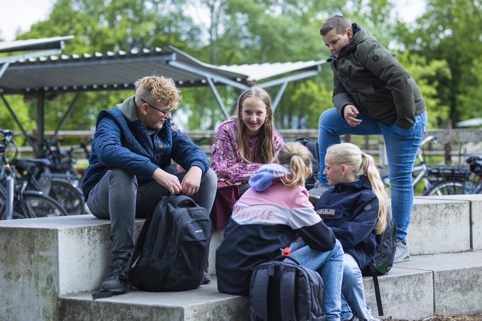 leerlingen buiten op bankje