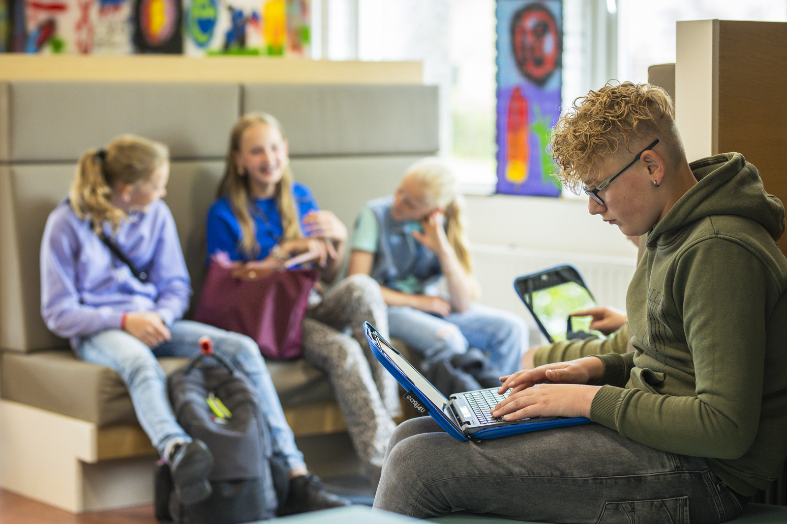 Leerlingen op een bank met een laptop
