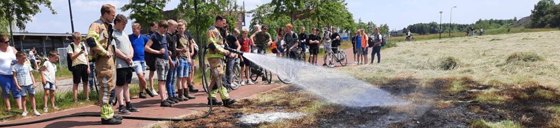 De brandweer en Leerlingen van het Aeres VMBO Heerenveen blussen samen een bermbrand