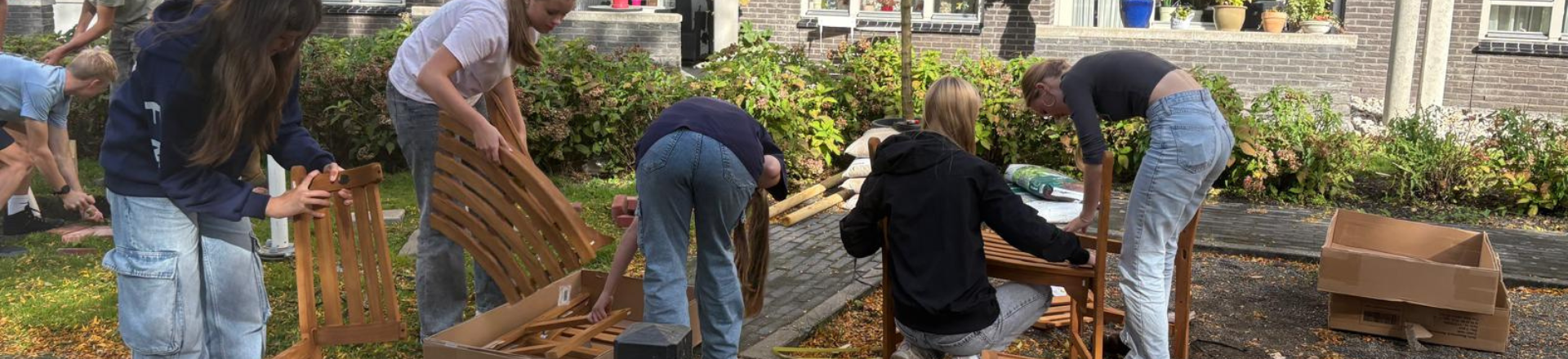Studenten werken aan een bankje bij woonzorgcentrum
